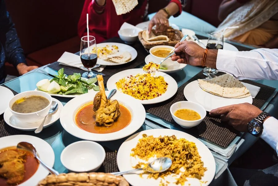 Traditional Eid ul Adha dishes served in a well-arranged catering setup at a UK event.